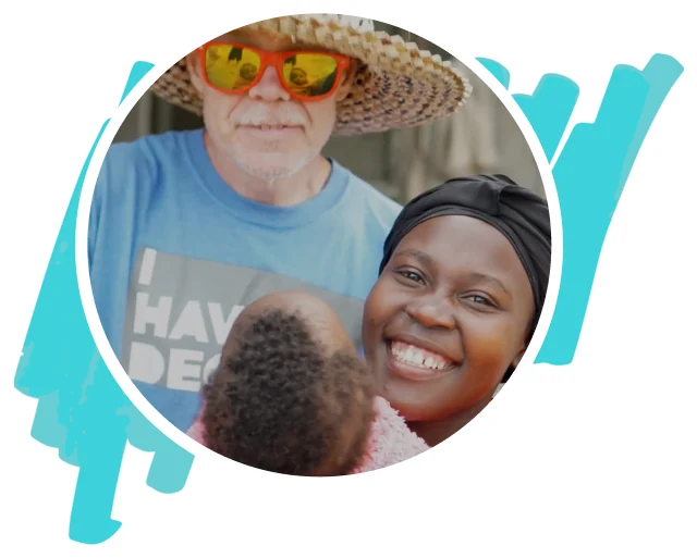 A ministry worker smiling with a mother and her baby